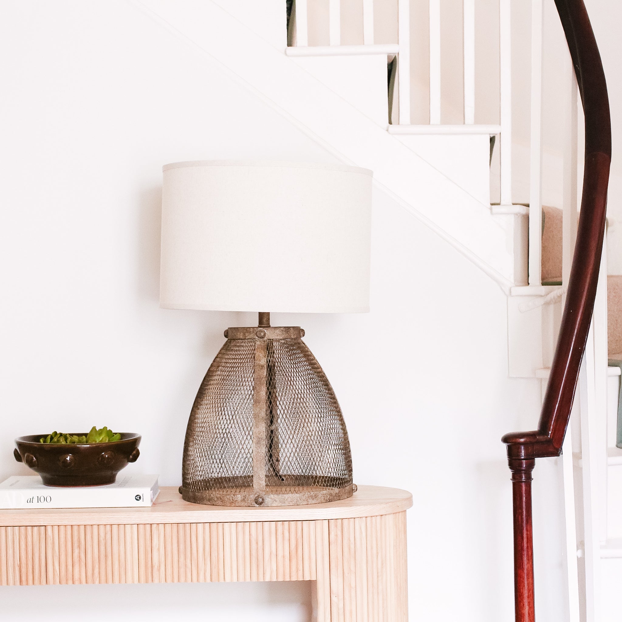 Fisherman cage lamp featuring a metal mesh base and a white lampshade