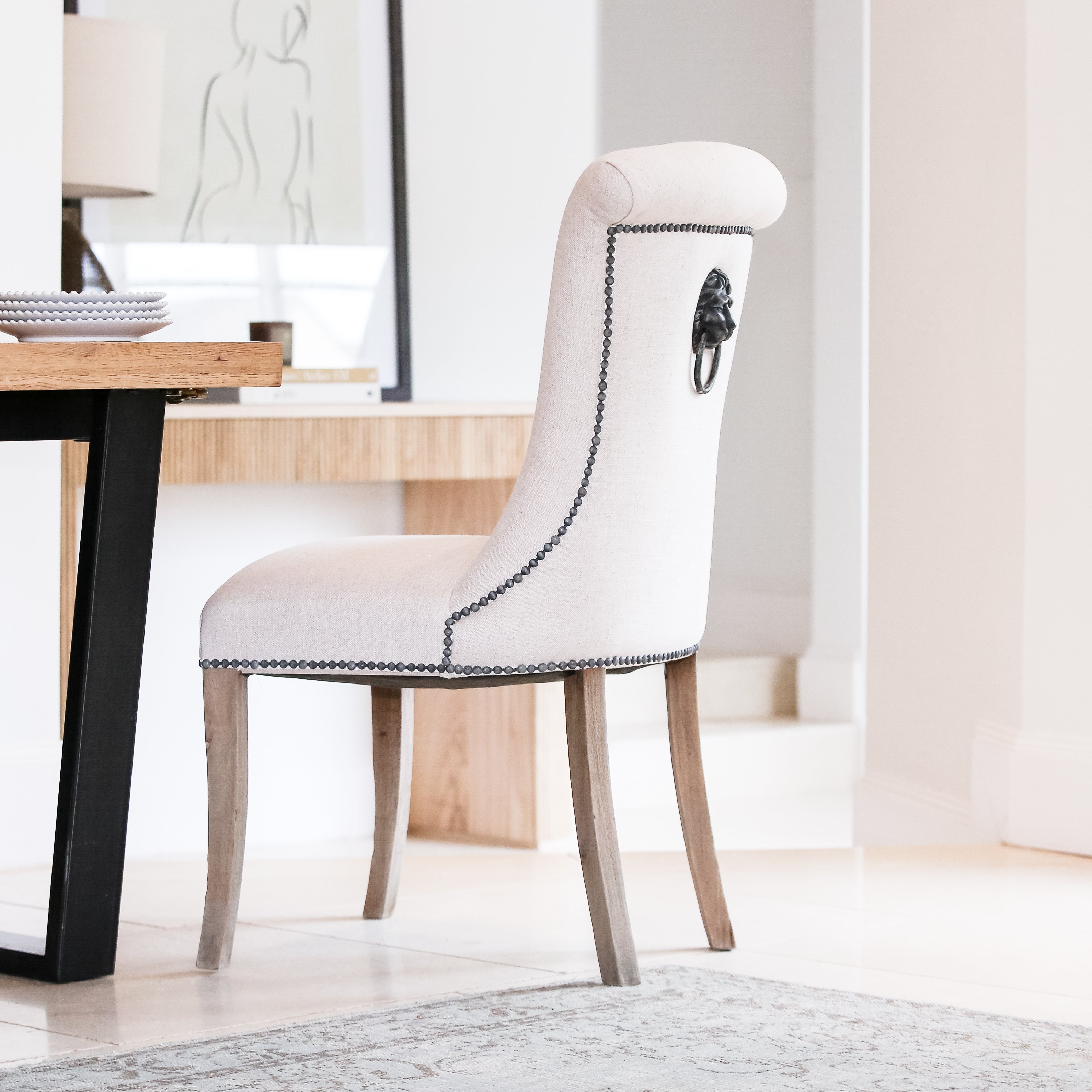 A striking dining chair in natural linen with stun detailing and ring back.