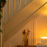 Decorative angel figure on a table with a candle next to a staircase