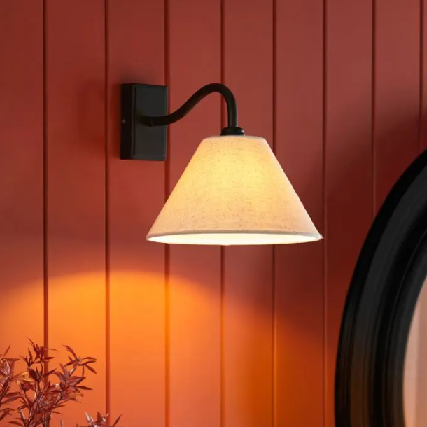 Dunston Matte Black Wall Light with curved arm and linen cone shade mounted on wall