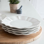 12-piece set of white ceramic scalloped dinner service.