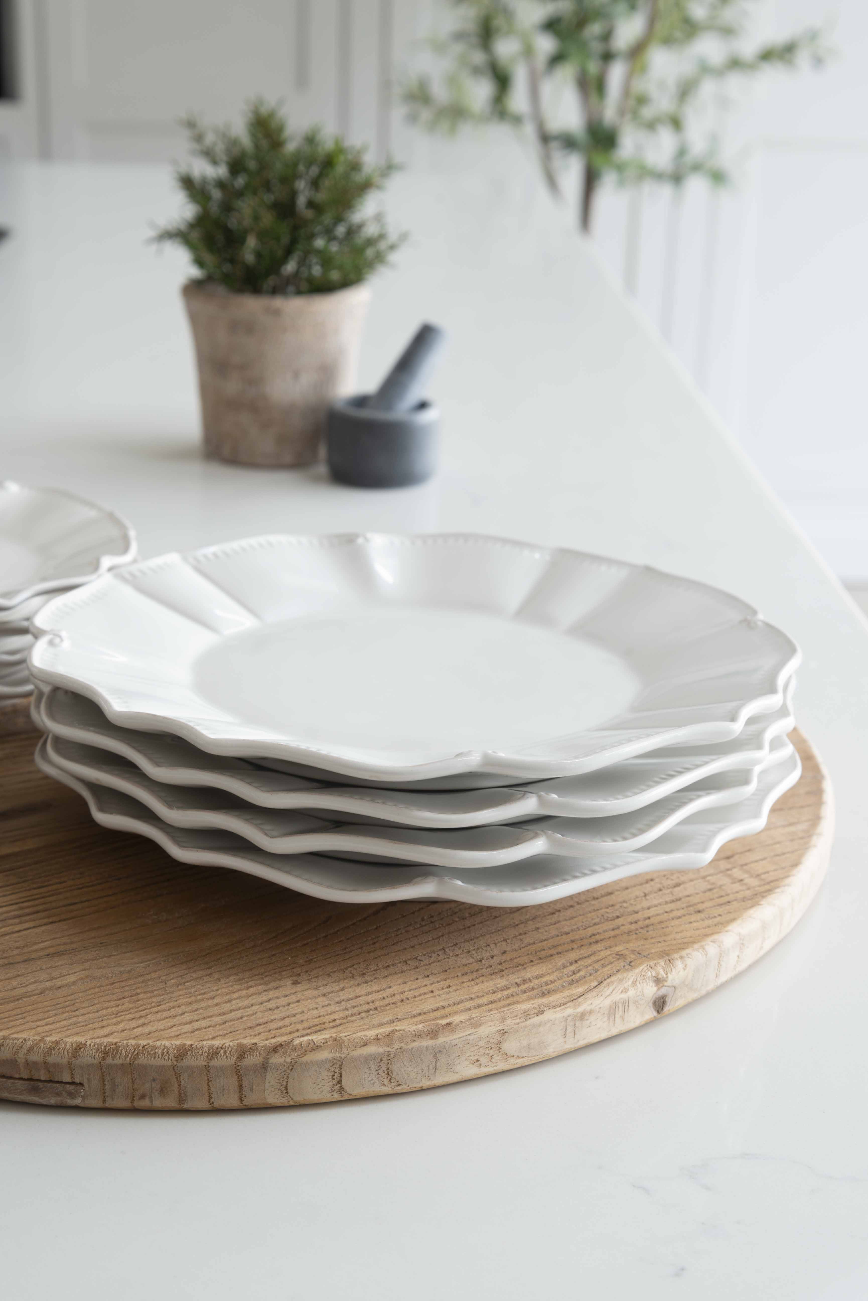 12-piece set of white ceramic scalloped dinner service.