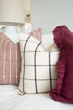 White and black checked cushion cover displayed on a sofa with coordinating pillows
