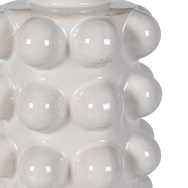 Close-up of the Eldon lamp's glossy white ceramic base, showing the rows of fully-rounded bobble texture and the highlights catching across the glaze