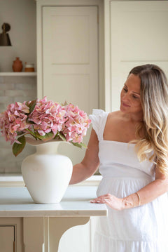 Bring effortless charm to your space with this beautifully crafted faux pink hydrangea, sold individually for versatile styling. Featuring lush, lifelike petals in soft blush tones and realistic green leaves, this artificial stem adds a delicate, romantic touch to any interior arrangement. Whether styled in a vase on your kitchen island, as shown, or combined with other stems for a fuller bouquet, it offers lasting beauty without maintenance.

Perfect for home décor, weddings, or gifting, this faux pink hyd
