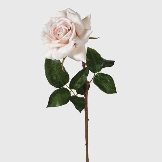 Lifelike faux rose stem with blush pink petals and green leaves on white background