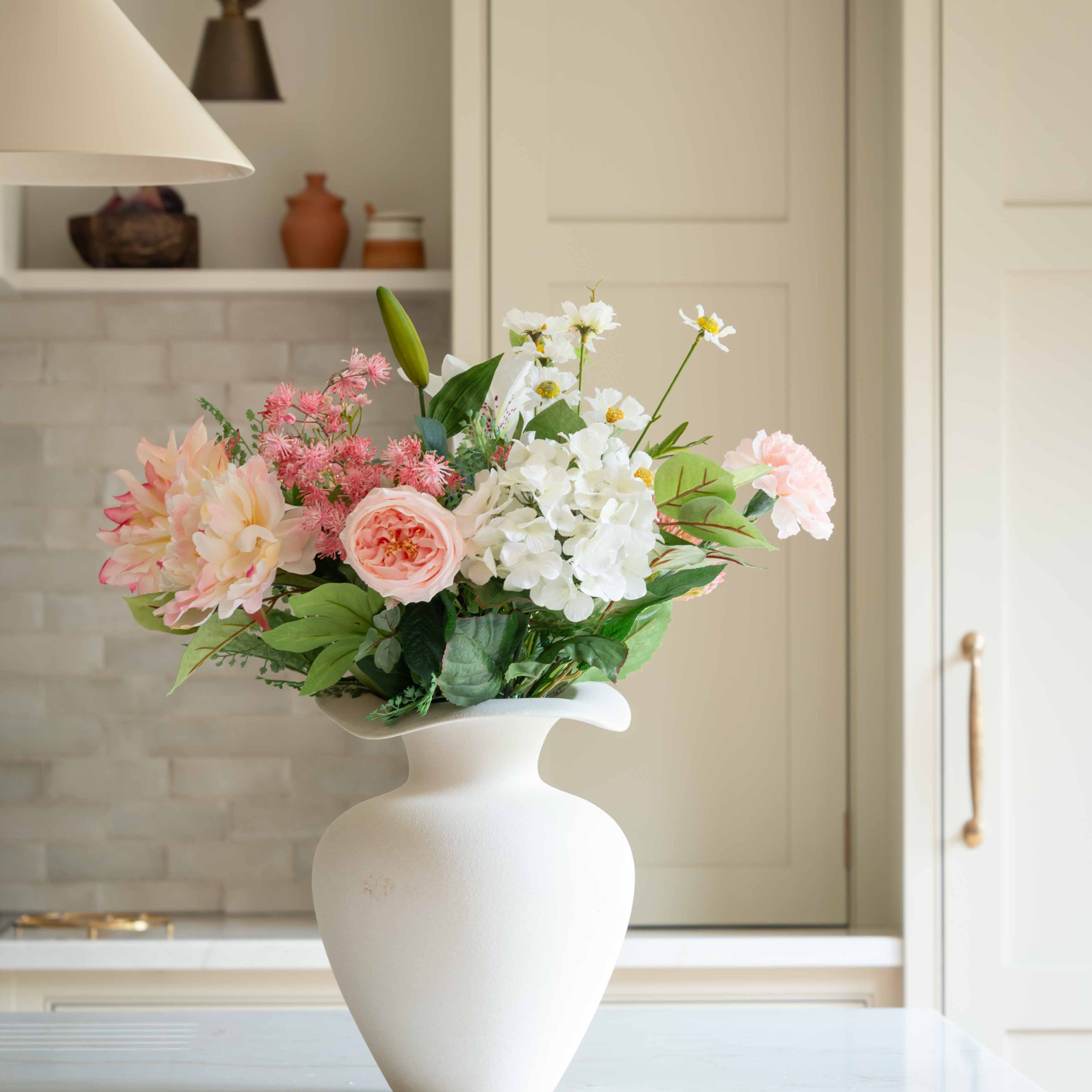 Bring timeless charm and natural beauty into any space with our Elegant Pastel Flower Bouquet, a handcrafted arrangement featuring soft blush pink roses, delicate white lilies, hydrangeas, daisies, and lush greenery. This luxury floral bouquet is designed to add a fresh, romantic touch to your home, wedding, or special occasion.

Perfectly wrapped in eco-friendly kraft paper, this premium artificial flower bouquet offers lasting beauty without the need for watering or maintenance. Whether displayed in a vas