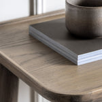 Elmore Oak Console Table top view with decorative items including a ceramic cup and book