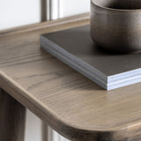 Elmore Oak Console Table top view with decorative items including a ceramic cup and book