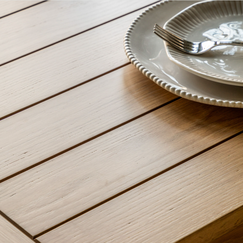 Close-up of Eton Table plank-style oak tabletop with ceramic plate and fork
