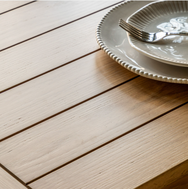 Close-up of Eton Table plank-style oak tabletop with ceramic plate and fork