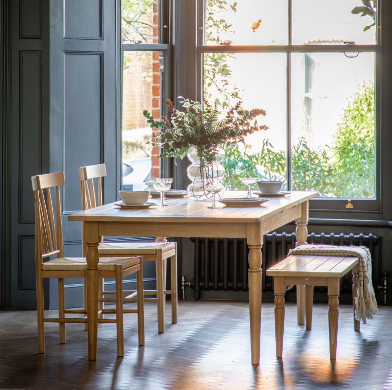 Bright dining space with Eton Oak Table, chairs, and bench near window