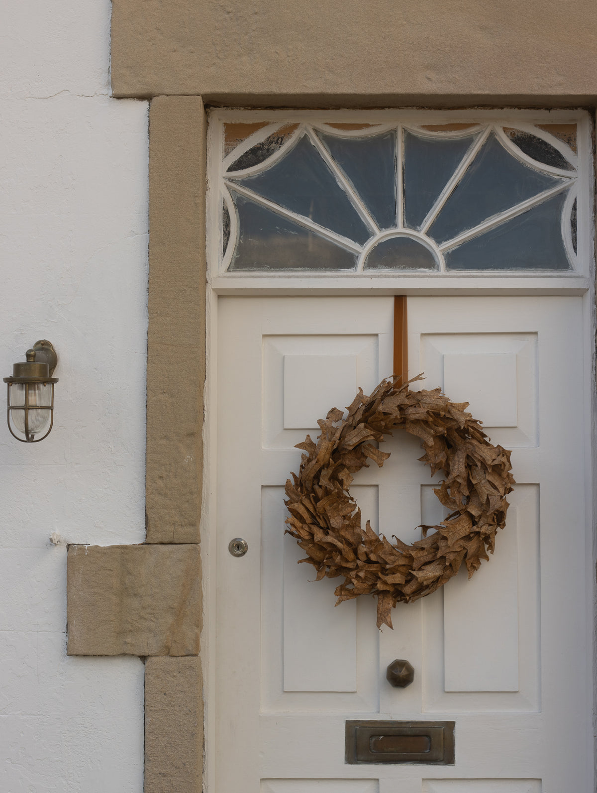 60cm dried leaf autumn wreath hanging on a white front door
