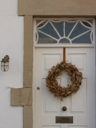 60cm dried leaf autumn wreath hanging on a white front door