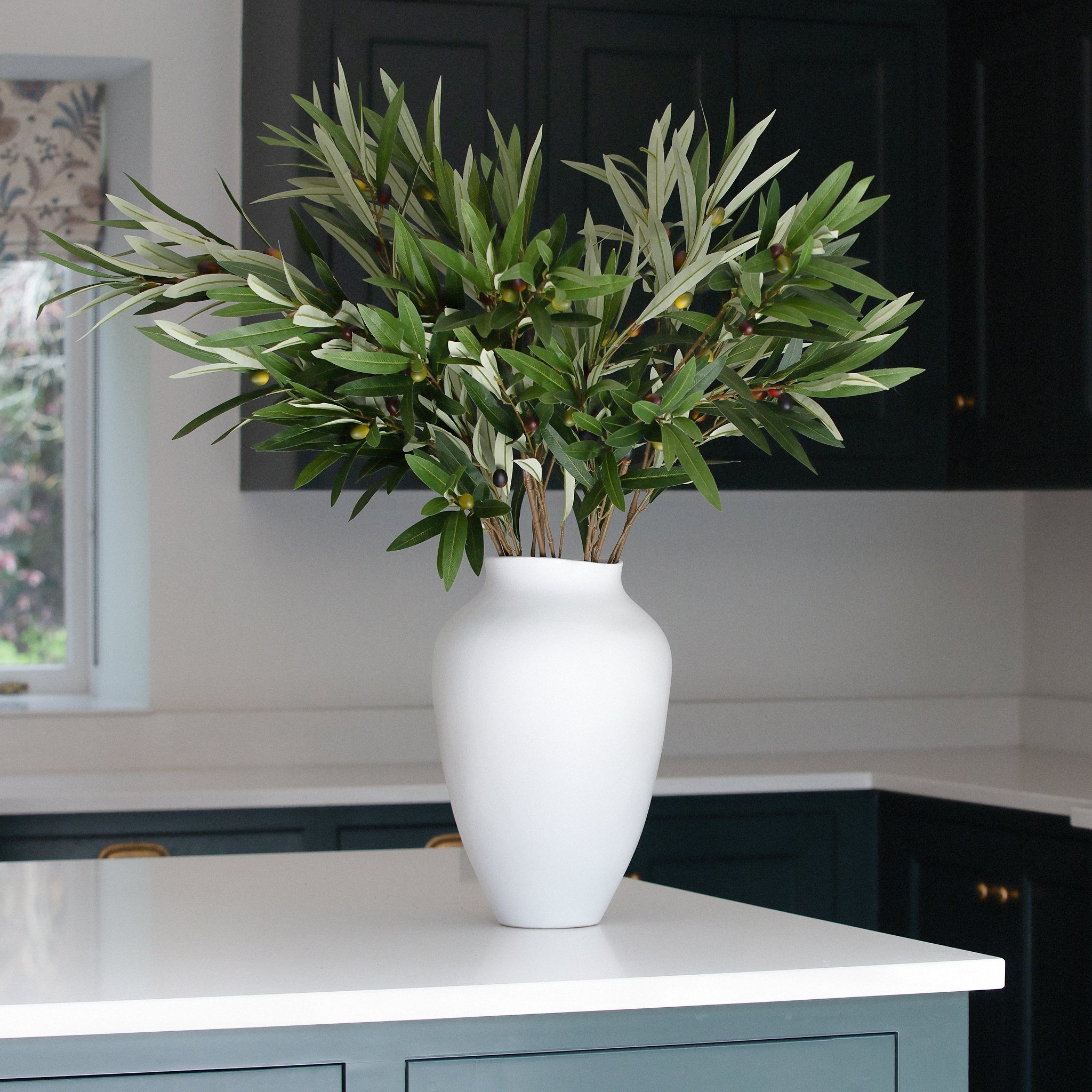 Bring a touch of Mediterranean elegance into your home with this Faux Olive Stem Set of 3. Featuring lifelike green leaves and realistic black and green olive details, each stem is expertly crafted to mimic the natural beauty of a real olive branch. Ideal for creating timeless floral arrangements, adding sophistication to vases, or enhancing centrepieces, these artificial olive stems offer all the charm without the maintenance.

Perfect for modern, farmhouse, or minimalist décor, this set of three artificia