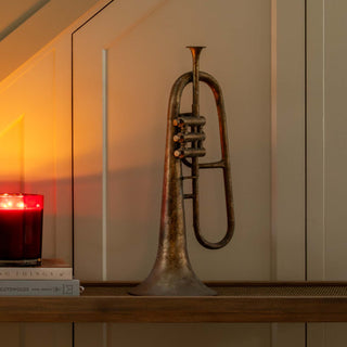 Decorative staircase with Christmas garland, candle, pinecones, and a trumpet.