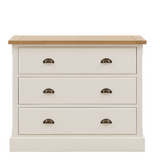 Florence 3 drawer chest of drawers in oak and white beside a bed with mirror and decor