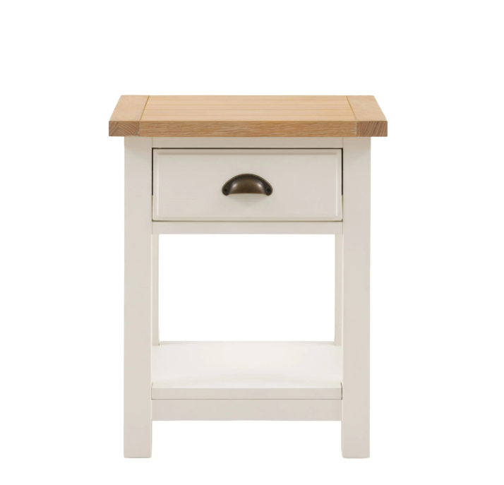 Florence bedside table in oak and white with drawer and open shelf beside a bed