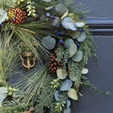 A beautiful full wreath, created using silver dollar eucalyptus, natural eucalyptus, blueberry stems, pine spray and finished with pine cones