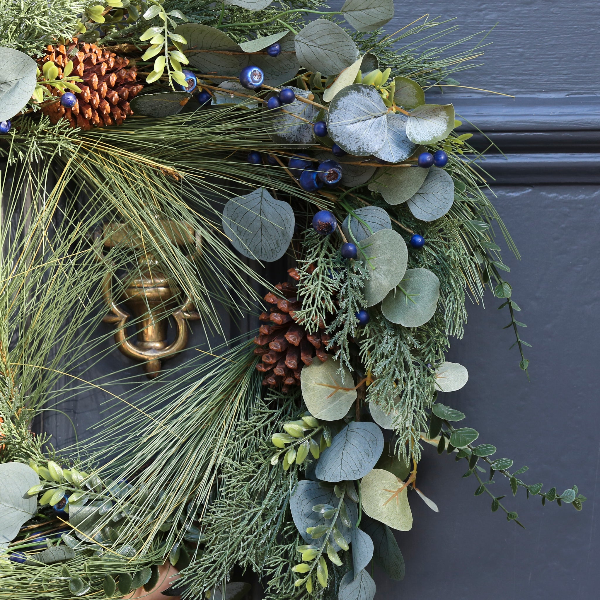 A beautiful full wreath, created using silver dollar eucalyptus, natural eucalyptus, blueberry stems, pine spray and finished with pine cones