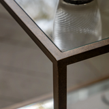 Geneva Glass Side Table with clear glass shelves and modern metal frame beside sofa