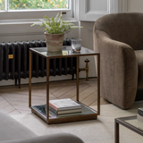 Geneva Glass Side Table with clear glass shelves and modern metal frame beside sofa