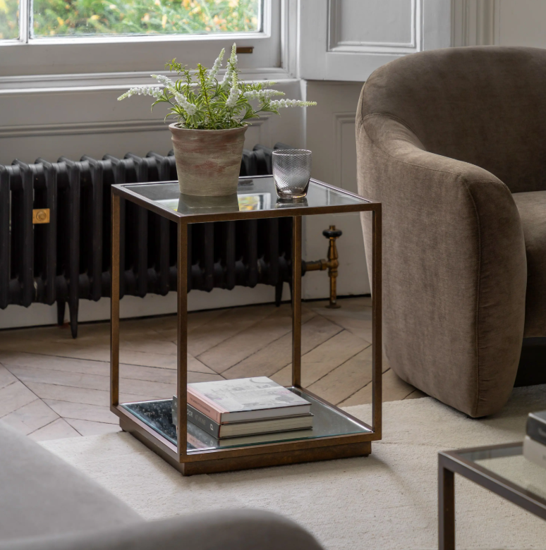 Geneva Glass Side Table with clear glass shelves and modern metal frame beside sofa