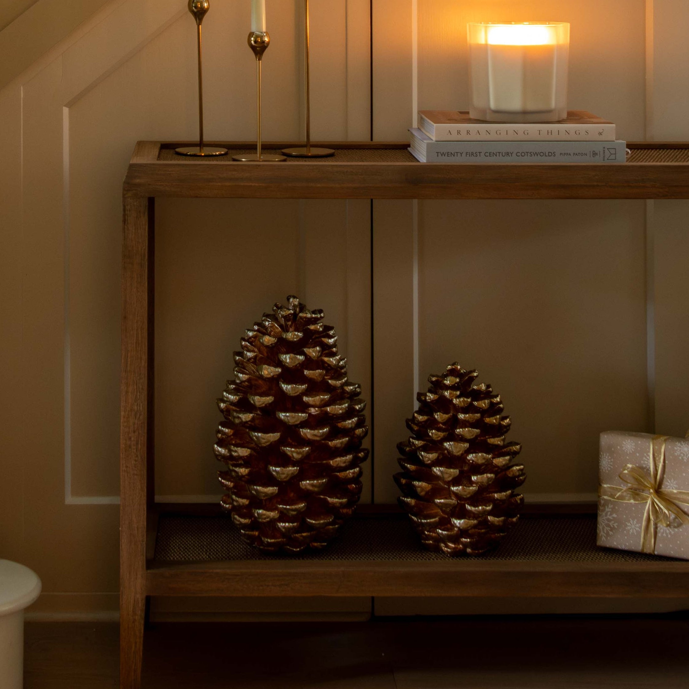 Decorative staircase with greenery, candles, and decorative items in a warm setting.