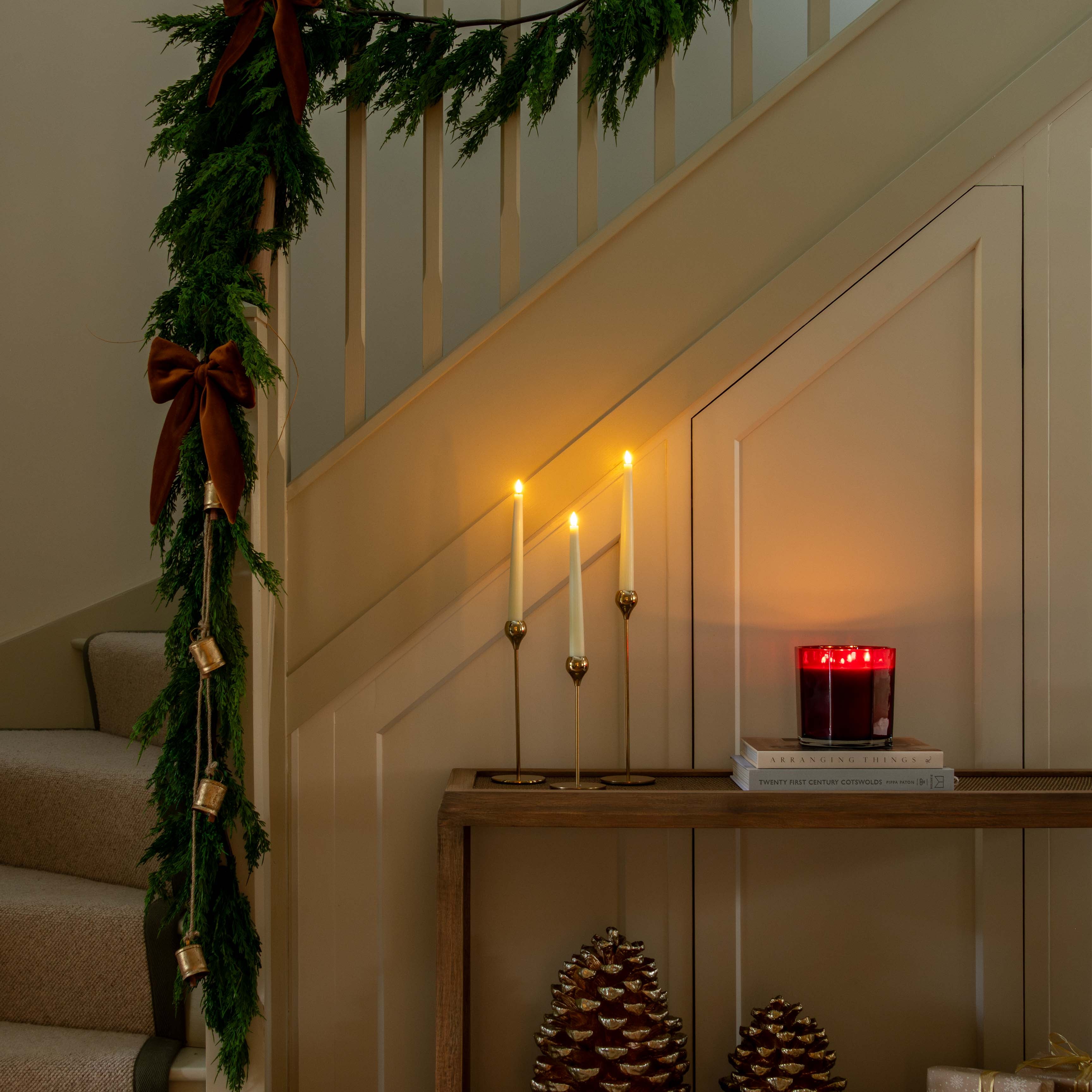 Decorative staircase with garland, candles, and decorative items in a warm setting.