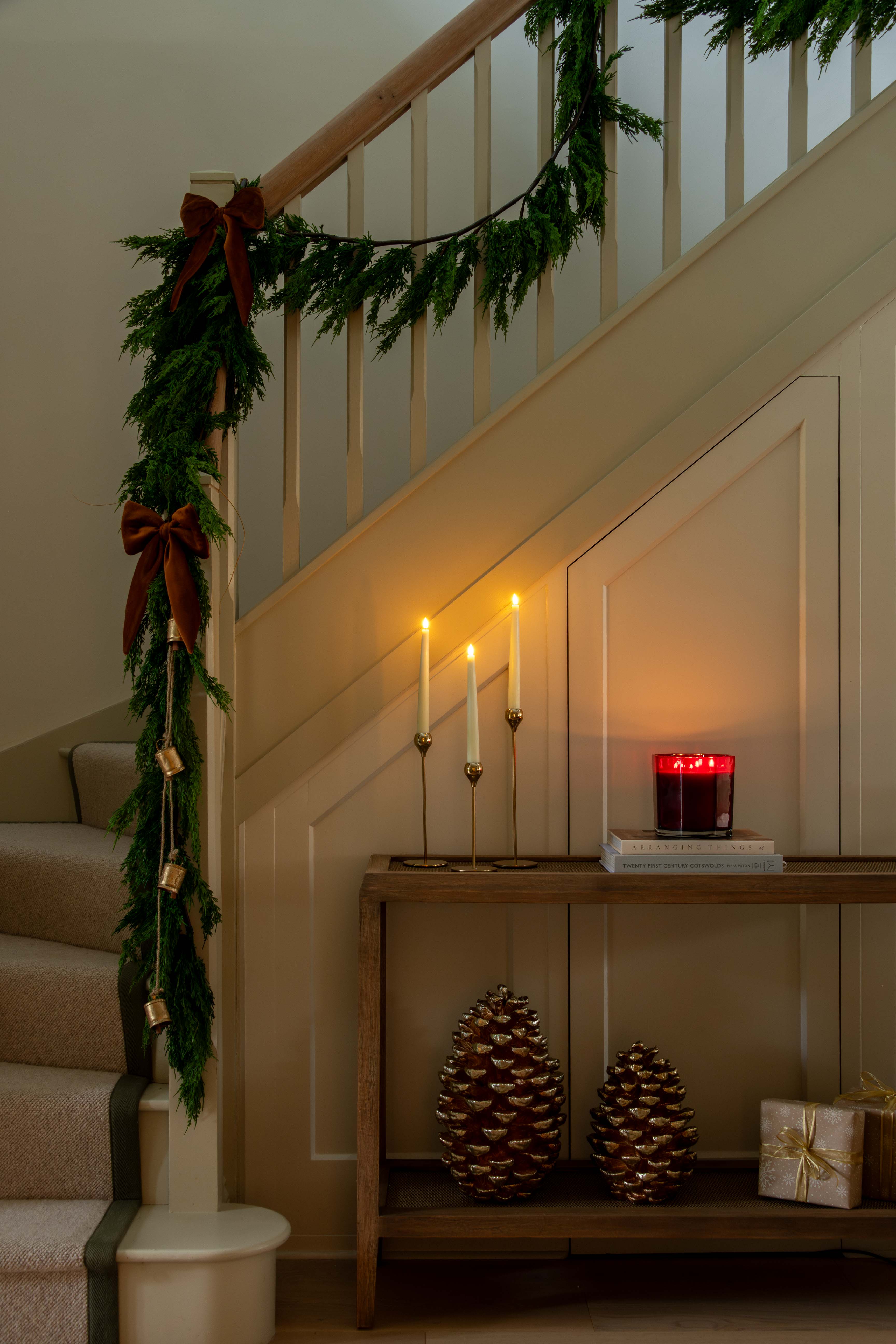 Decorative staircase with garland, candles, and decorative items in a warm setting.
