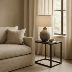 Grafton Industrial End Table with faux concrete top and slate grey metal frame beside beige sofa and ceramic lamp