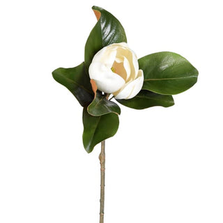 A single artificial magnolia flower stem with glossy dark green leaves and a large white blooming flower on a plain white background.