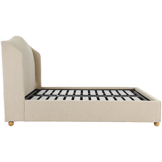 Side profile of the Harlyn upholstered bed with turned wooden bun feet and low base