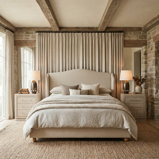 Harlyn winged linen bed styled in a rustic country bedroom with stone walls