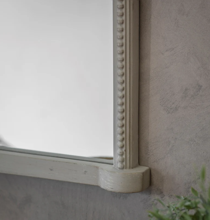 Arched wall mirror with decorative crest and beaded frame in a vintage gray finish