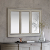 The Harrison Panel Mirror with a three-panel rectangular design and elegant wooden frame, mounted above a console table with soft neutral décor.