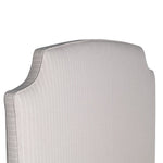 Henrietta upholstered bed with curved padded headboard and neutral fabric finish