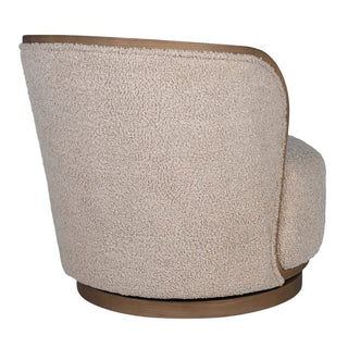 three-quarter angled view of the Holkham bouclé swivel chair, showing the architectural curve of the wood frame and the rotating wooden plinth base