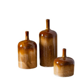 Three brown ceramic bottles of varying sizes on a white background