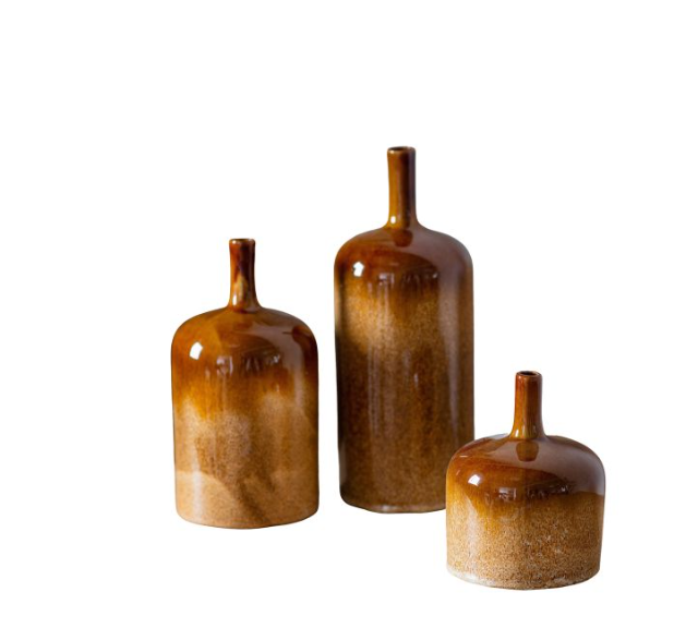 Three brown ceramic bottles of varying sizes on a white background