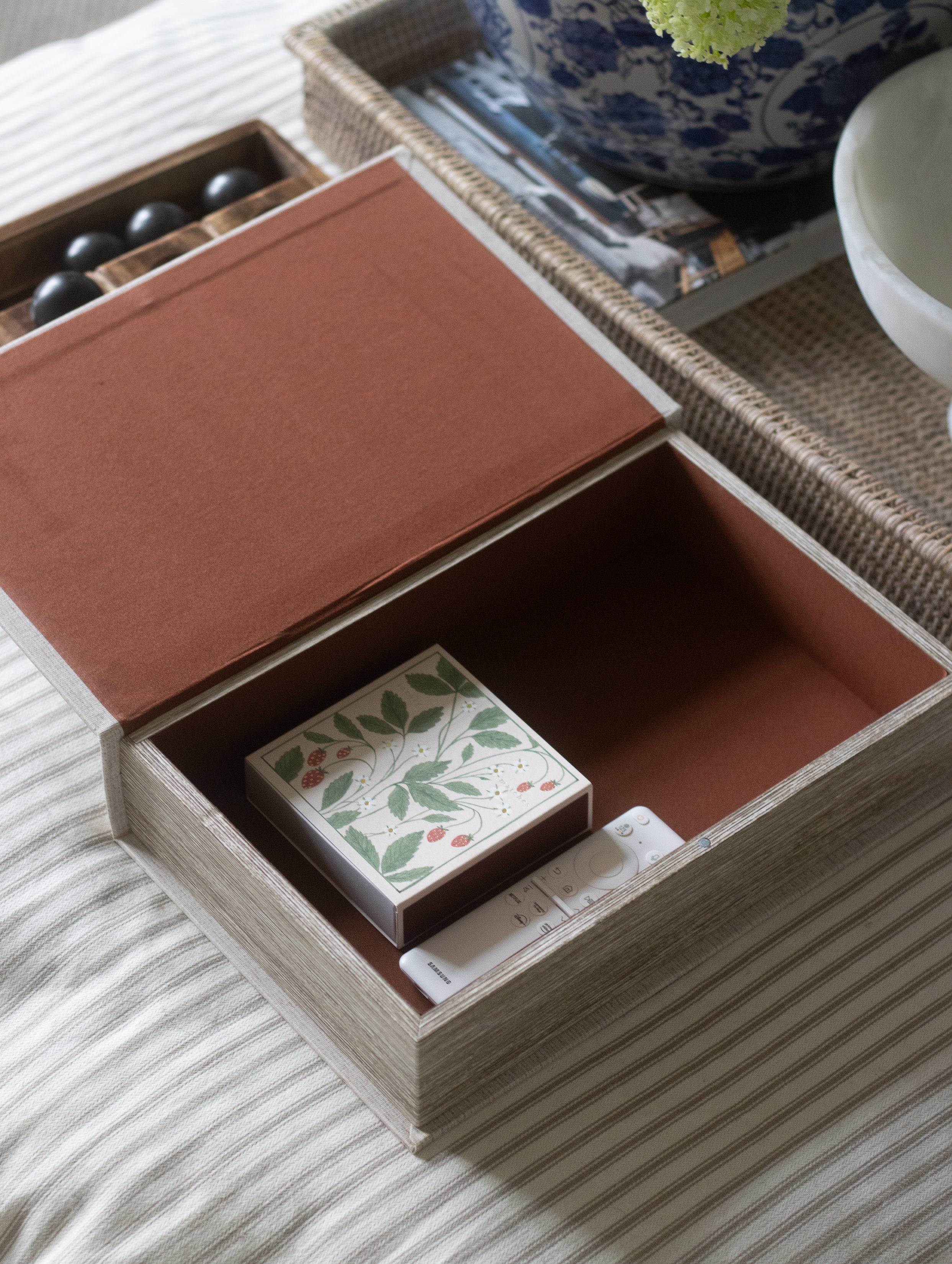 Open wooden box with a decorative item on a striped fabric surface