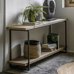 Modern console table styled with basket, books, and decorative vase in a hallway setting