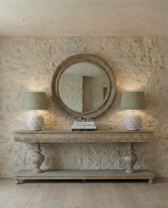 Wooden console table with decorative pedestal base against a plain wall