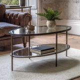 Jenner bronze glass coffee table with two tier oval glass shelves in a modern living room setting