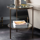 Jenner bronze glass side table with two tier round glass shelves beside a sofa in a modern interior