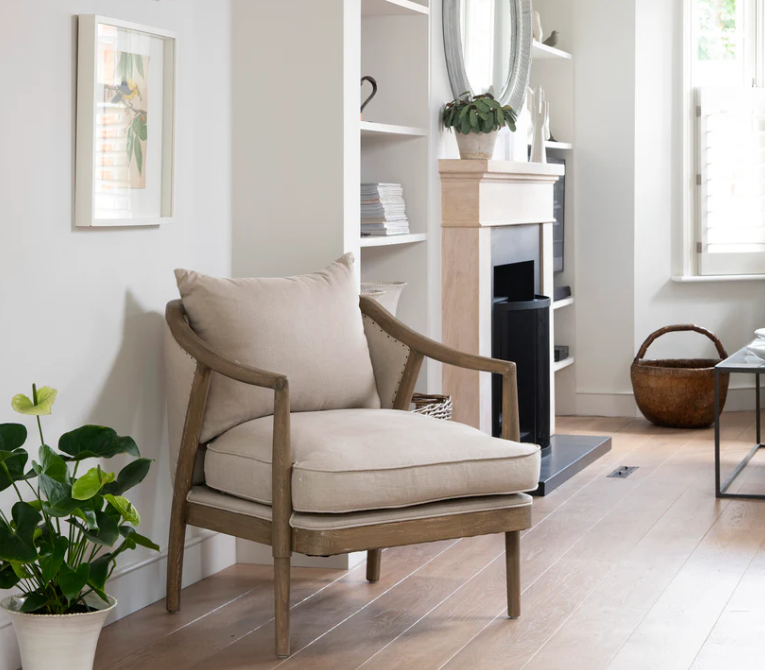 Linen occasional armchair with solid wood frame, curved arms, and cushioned seat in a modern living room