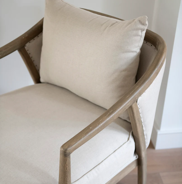 Beige armchair with a cushion on a neutral background