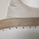 Close-up of a wooden chair on a beige fabric surface