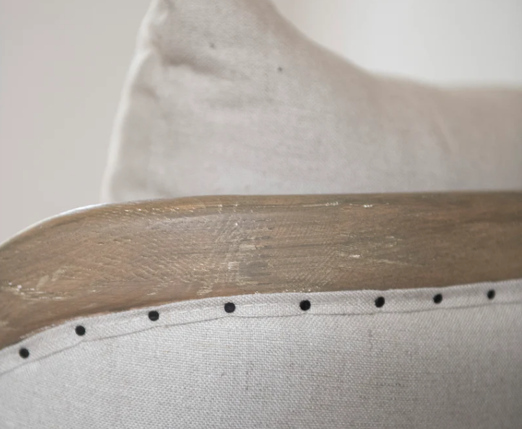 Close-up of a wooden chair on a beige fabric surface