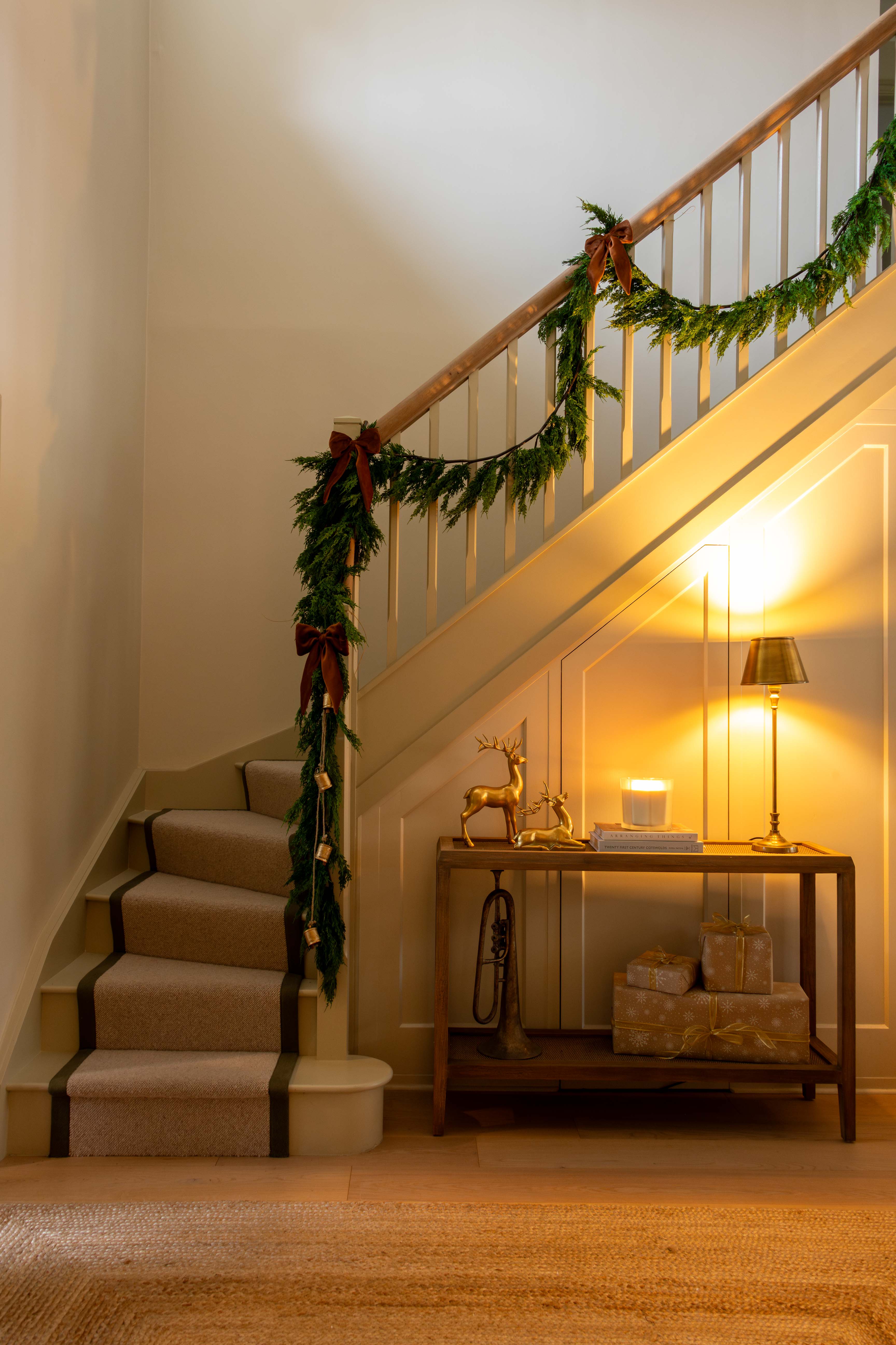 Decorative staircase with garland, lights, and a small table with a deer figurine.